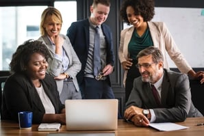 Diverse team of professionals collaborating around a laptop
