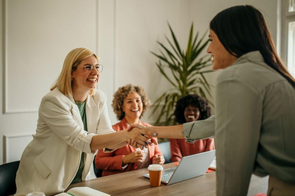 Business professionals shaking hands in modern office meeting room