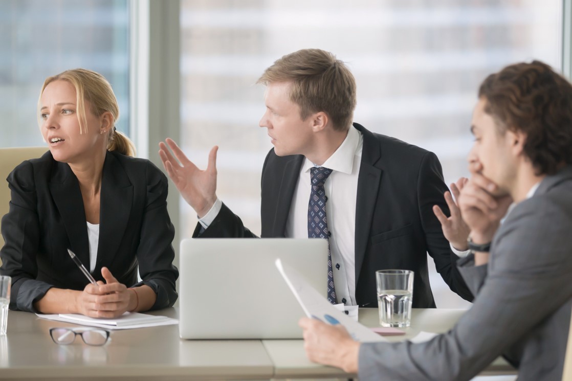 Business professionals in heated discussion during office meeting