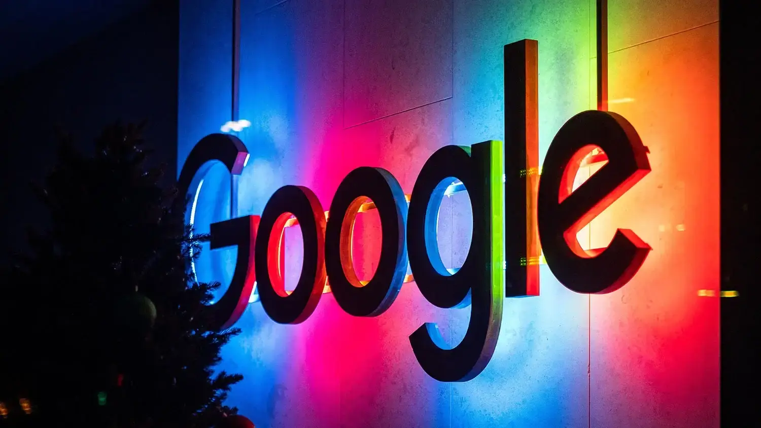 Google logo with colorful rainbow lighting in background